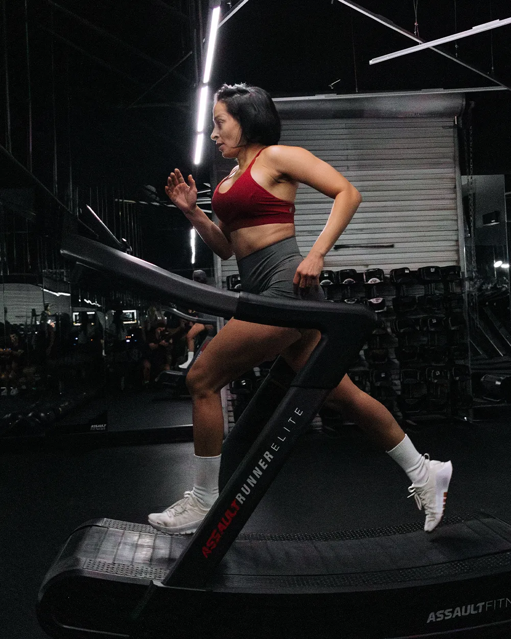Woman running on an a treadmill in a gym.