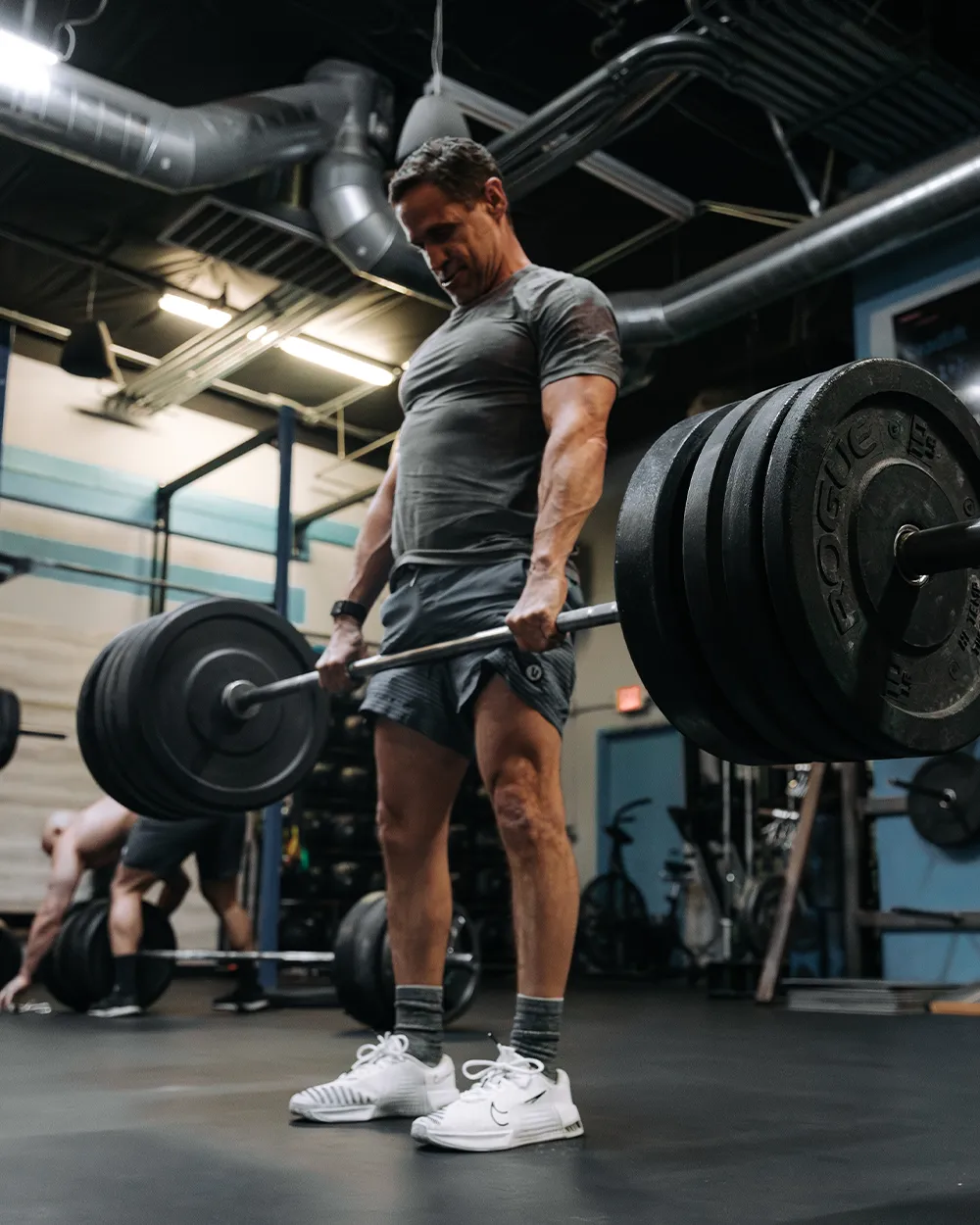 Athlete deadlifts heavy weights in a gym.